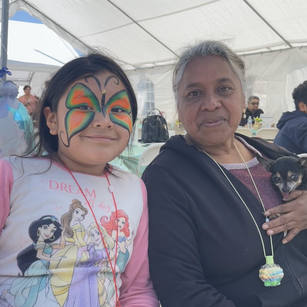 Young Girl with Face Paint Sitting Next to Grandmother